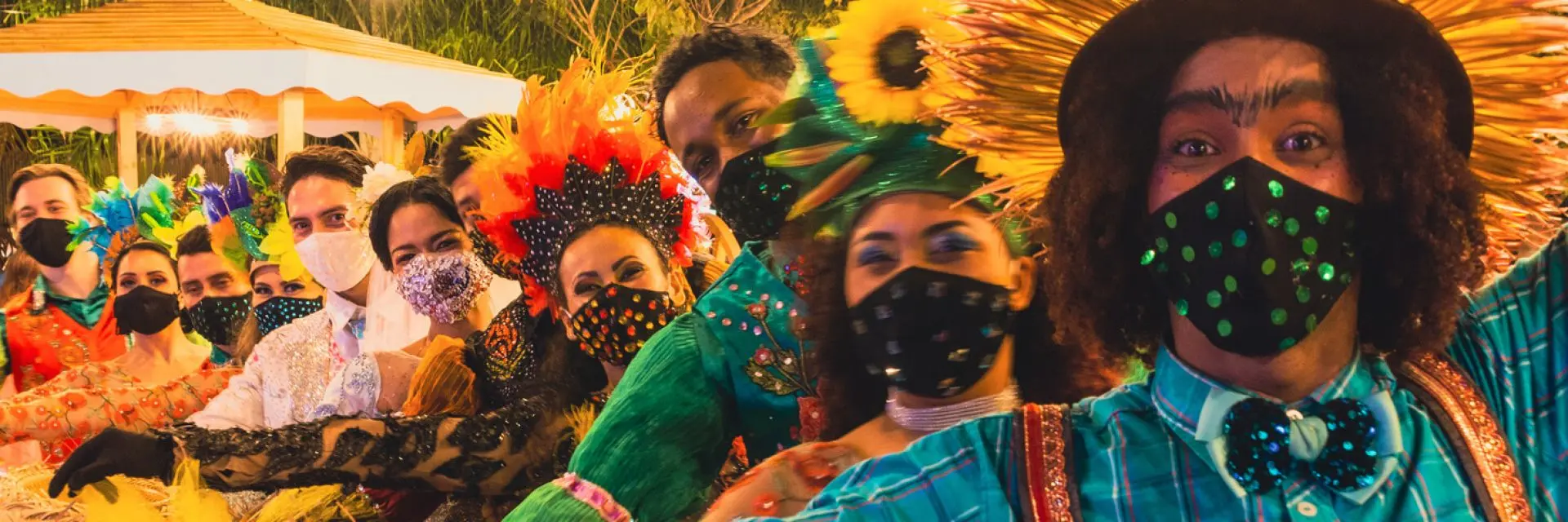 Imagem de um grupo de pessoas vestidos com roupas típicas de Festa Junina para dançar quadrilha.