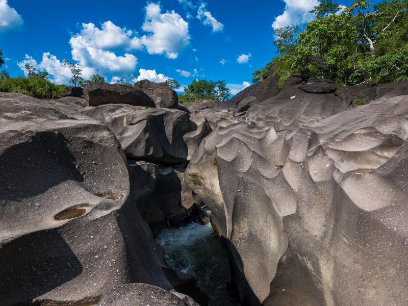 Pedras que parecem o solo lunar, com um rio passando abaixo, na Chapada dos Veadeiros