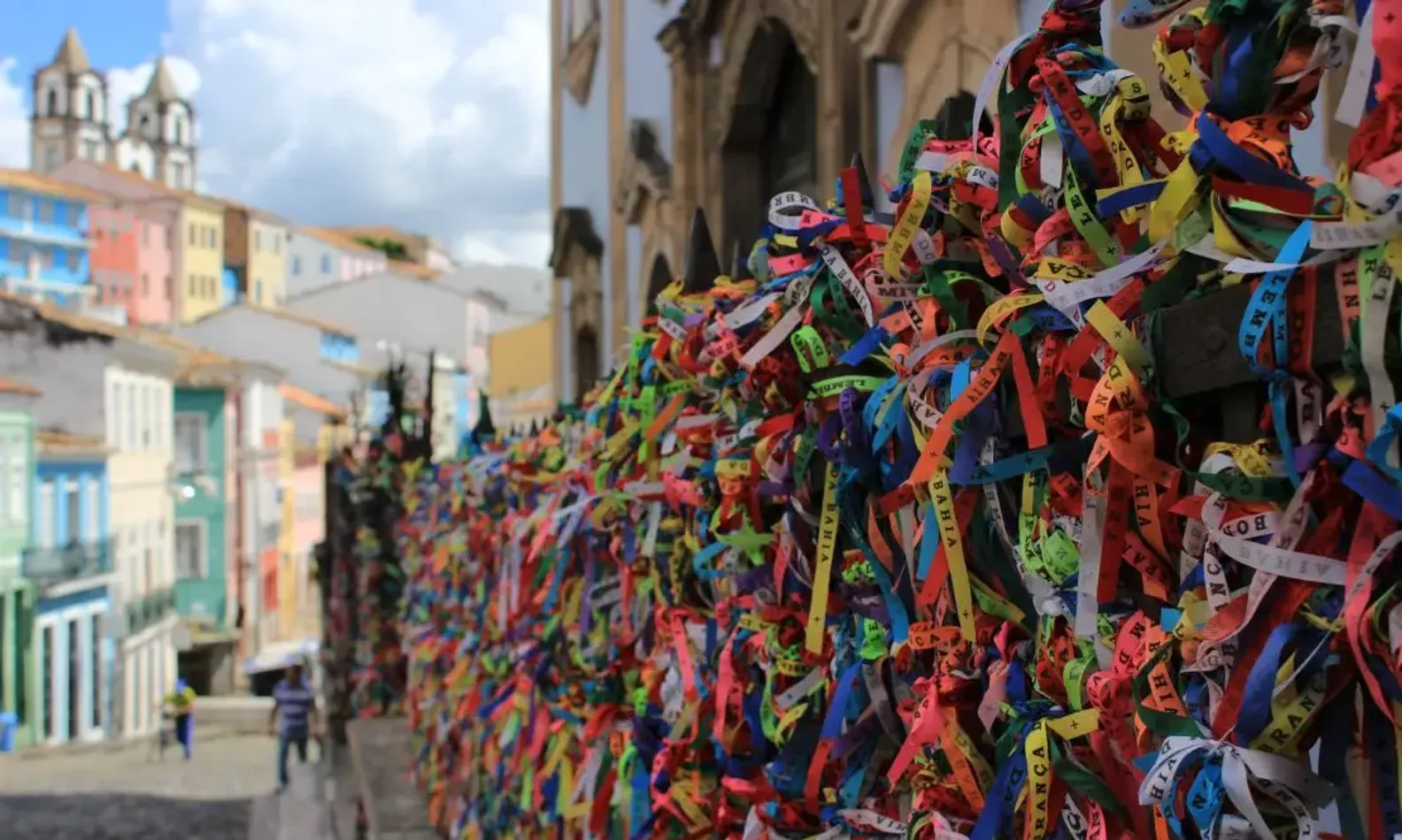 Parte de uma rua do Pelourinho, em Salvador, com fitinhas do Bonfim amarradas em um portão