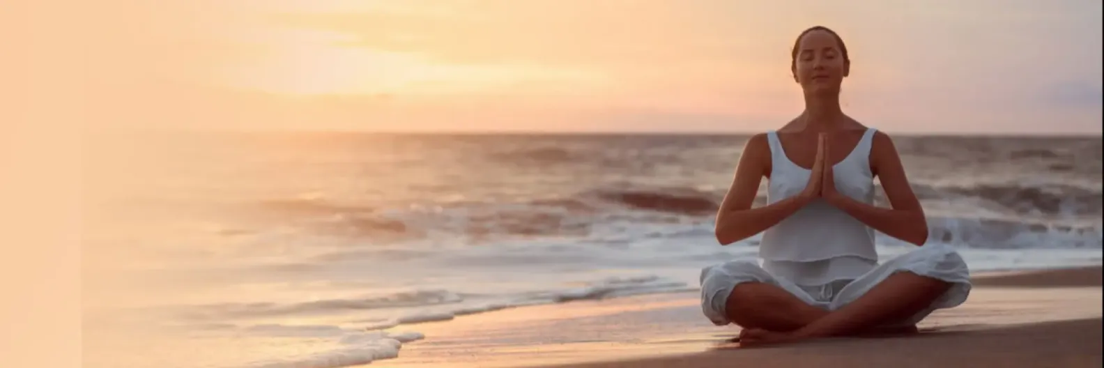 Imagem de uma mulher aprendendo como meditar em uma praia