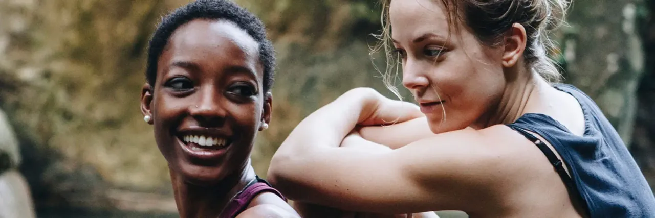 Imagem de duas mulheres sentadas em meio a natureza