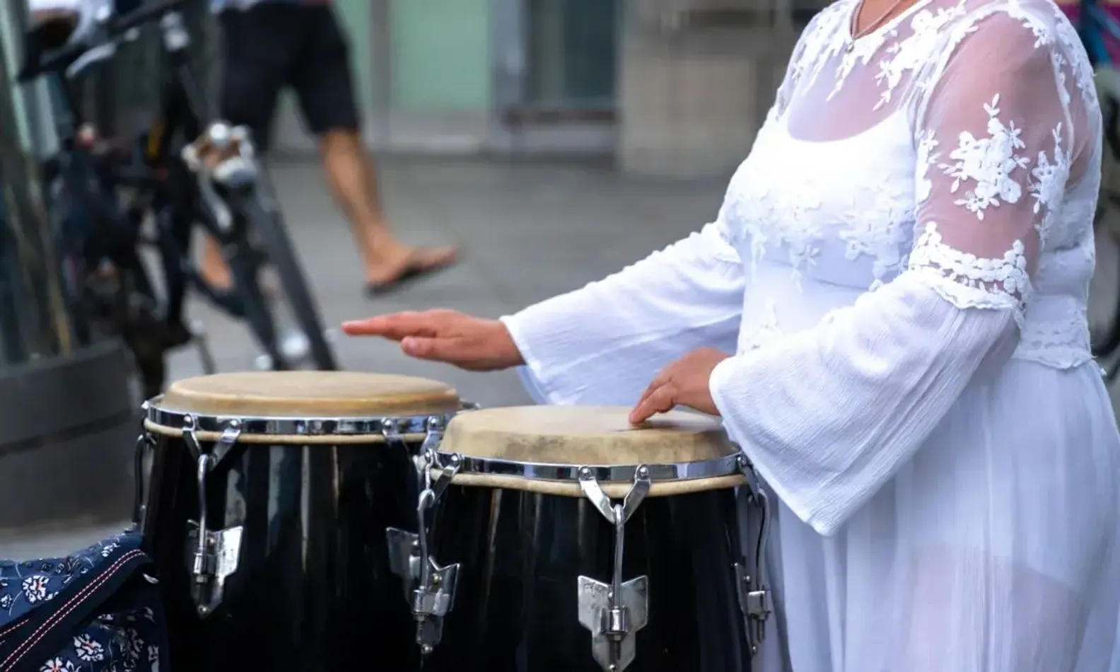 Parte do corpo de uma mulher tocando tambores típicos do samba reggae baiano