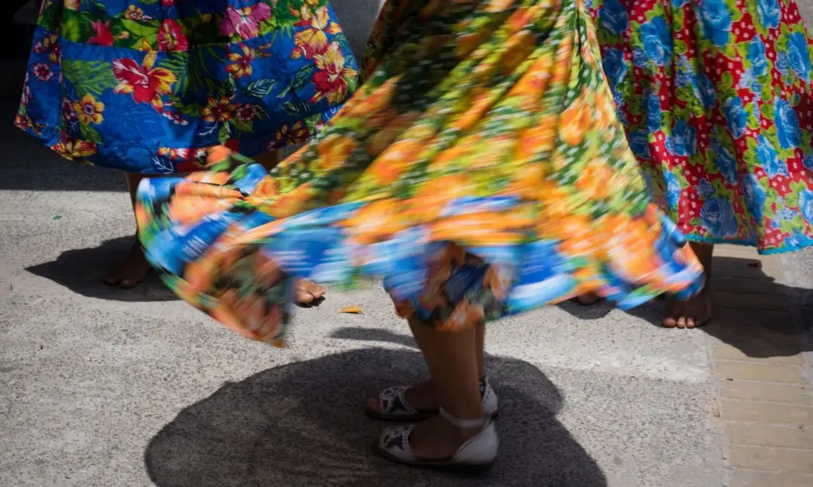 Parte das saias de três mulheres que dançam em um samba de roda